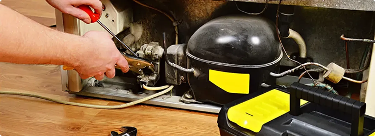 Refrigerator repair technician fixing the compressor and wiring in San Manuel, AZ