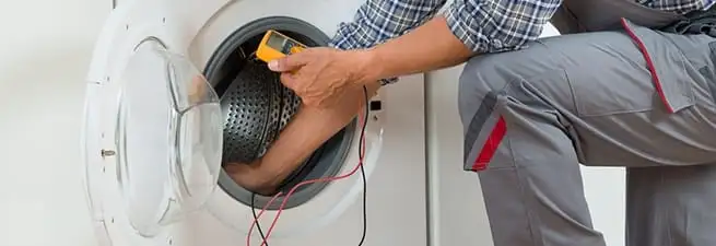 Dryer repair technician inspecting and repairing a clothes dryer in Tucson, AZ